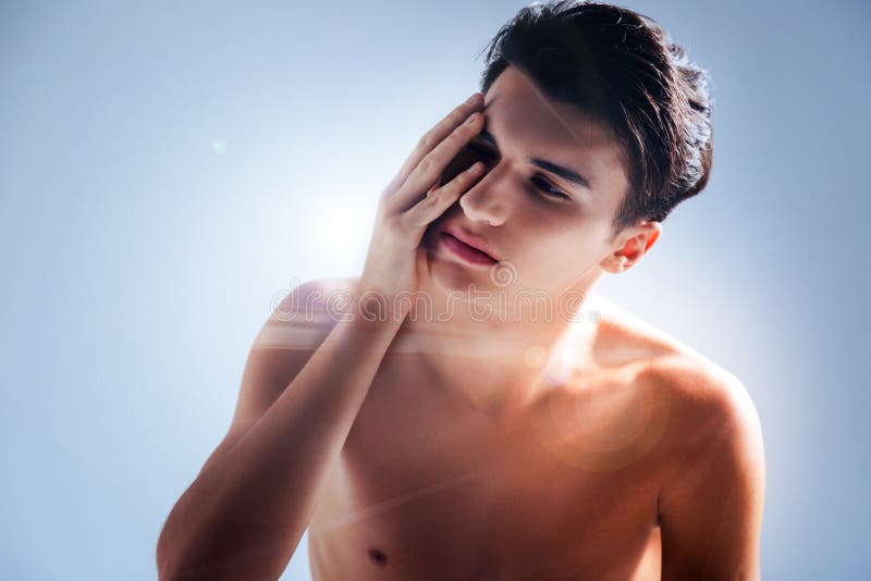 Jeune homme agréable touchant son visage images stock Jeune homme agréable touchant son visage images stock