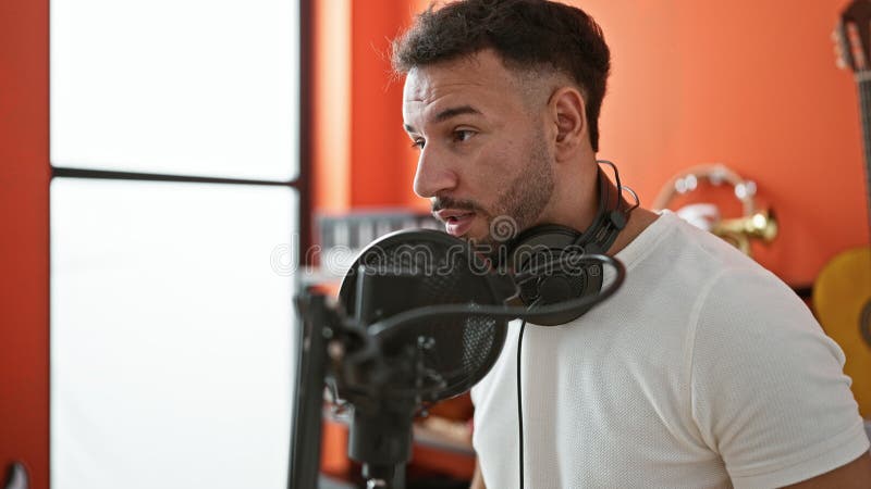 Jeune homme arabe musicien chantant une chanson au studio de musique