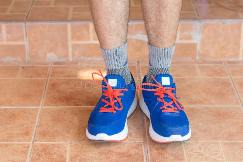 Jeune homme asiatique d'athlète attachant les chaussures de course dans la maison avant, mâle photos stock Jeune homme asiatique d'athlète attachant les chaussures de course dans la maison avant, mâle photos stock