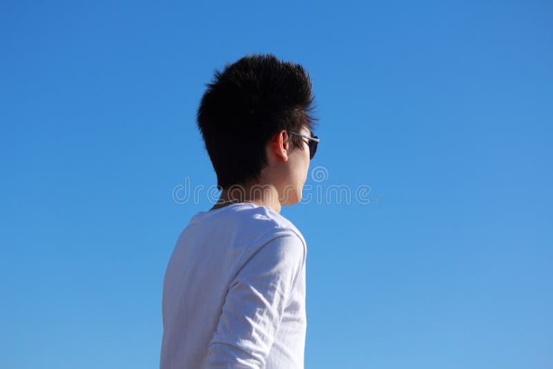 Jeune homme asiatique détendant le long de la plage photographie stock libre de droits Jeune homme asiatique détendant le long de la plage photographie stock libre de droits