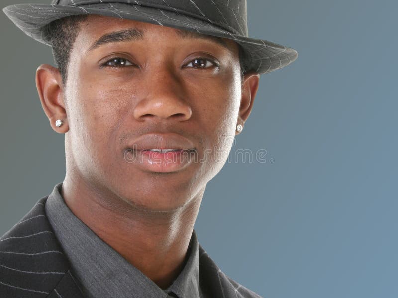 Jeune homme attirant dans le procès et le chapeau de filet photographie stock Jeune homme attirant dans le procès et le chapeau de filet photographie stock