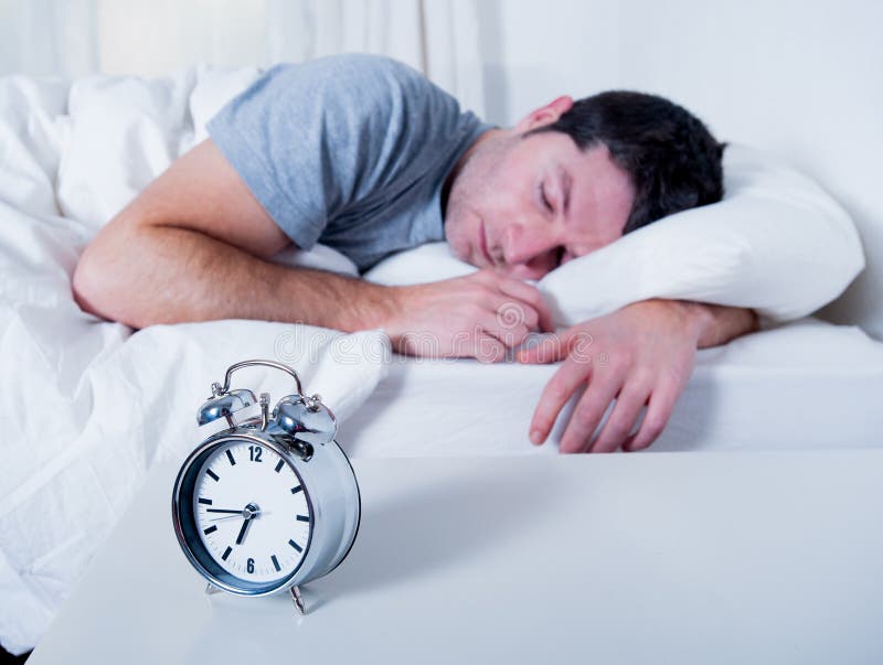 Jeune homme attirant dormant sur le lit images libres de droits Jeune homme attirant dormant sur le lit images libres de droits