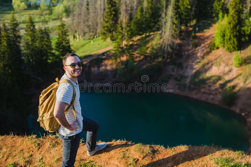 Jeune homme augmentant la verticale heureuse de sourire Randonneur masculin marchant dans la forêt image libre de droits Jeune homme augmentant la verticale heureuse de sourire Randonneur masculin marchant dans la forêt image libre de droits
