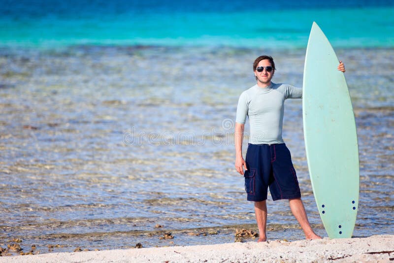 Jeune homme avec la planche de surf photo stock Jeune homme avec la planche de surf photo stock
