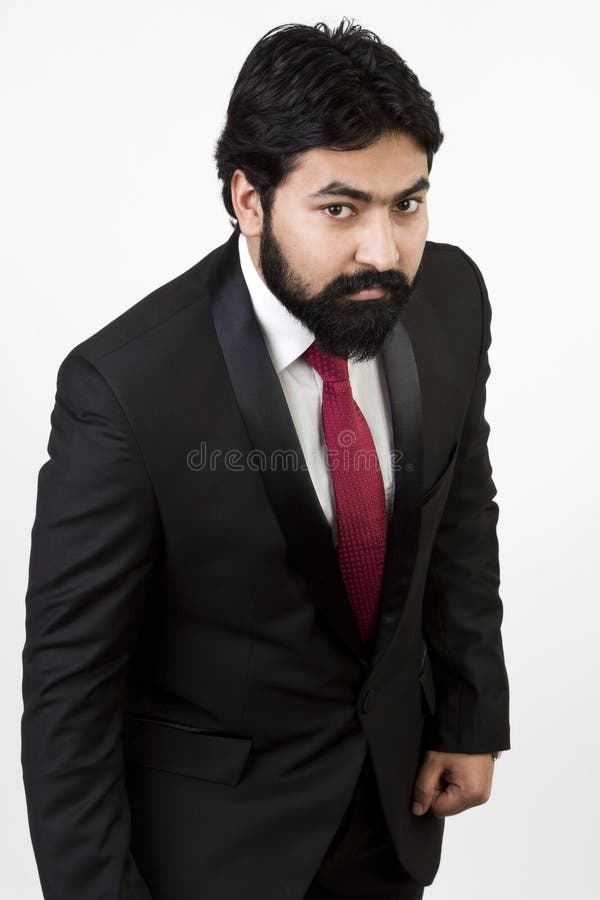 Jeune homme beau dans un smoking se penchant en avant image stock Jeune homme beau dans un smoking se penchant en avant image stock