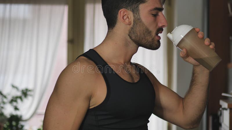 Jeune homme buvant une boisson de smoothie ou une secousse de protéine images libres de droits Jeune homme buvant une boisson de smoothie ou une secousse de protéine images libres de droits