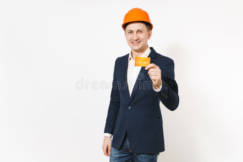 Jeune homme d'affaires de sourire bel dans le costume foncé, casque orange de construction protectrice jugeant la carte de crédit images libres de droits Jeune homme d'affaires de sourire bel dans le costume foncé, casque orange de construction protectrice jugeant la carte de crédit images libres de droits