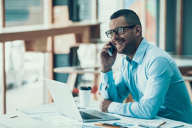 Jeune homme d'affaires de sourire travaillant dans le bureau image libre de droits Jeune homme d'affaires de sourire travaillant dans le bureau image libre de droits