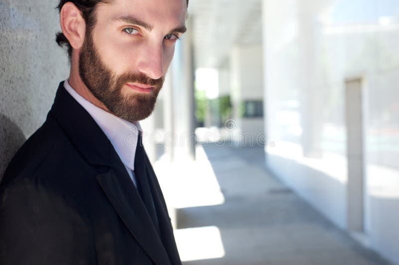 Jeune homme d'affaires frais avec la barbe posant dehors photo stock Jeune homme d'affaires frais avec la barbe posant dehors photo stock