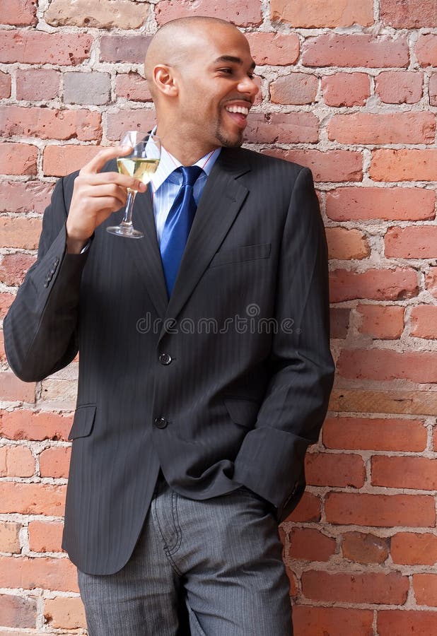 Jeune homme d'affaires riant avec une glace de vin images libres de droits Jeune homme d'affaires riant avec une glace de vin images libres de droits