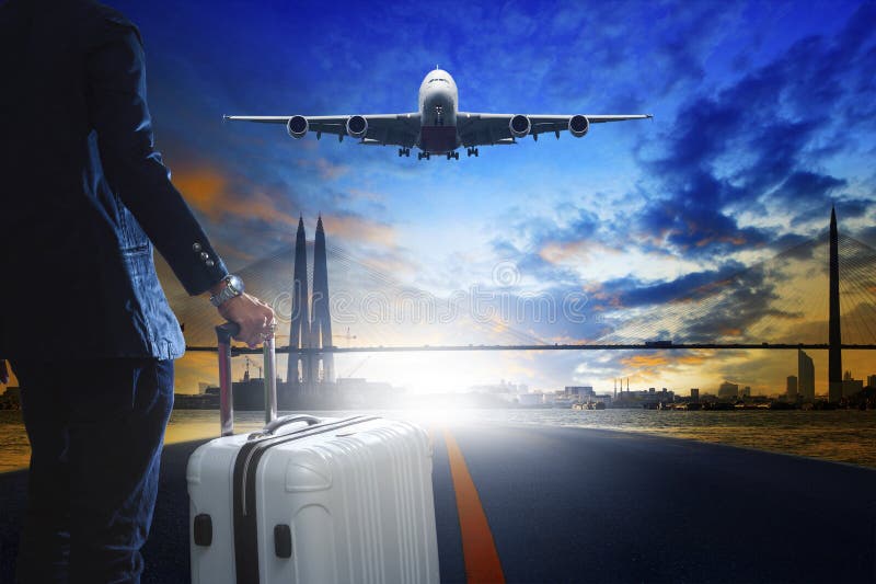 Jeune homme d'affaires se tenant avec le bagage sur la piste urbaine d'aéroport image libre de droits Jeune homme d'affaires se tenant avec le bagage sur la piste urbaine d'aéroport image libre de droits