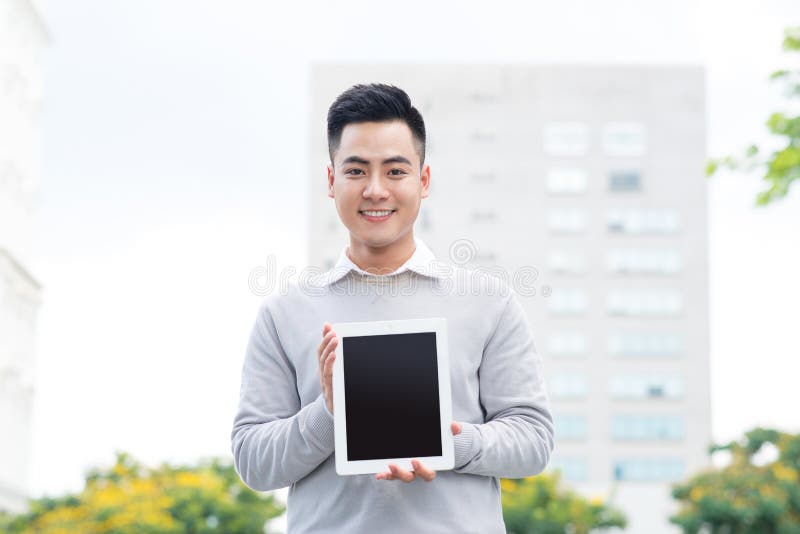 Jeune homme d'affaires tenant et montrant l'écran du comprimé photos stock Jeune homme d'affaires tenant et montrant l'écran du comprimé photos stock
