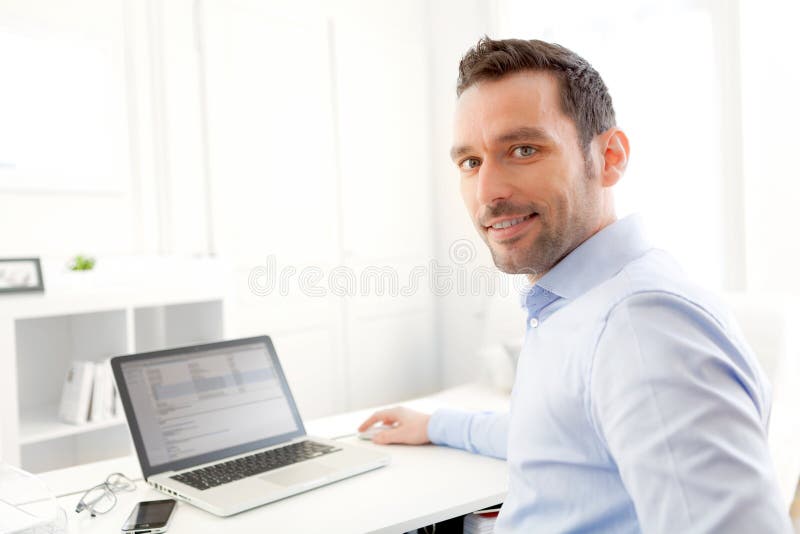 Jeune homme d'affaires travaillant à la maison sur son ordinateur portable