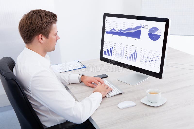 Jeune homme d'affaires utilisant l'ordinateur au bureau image libre de droits Jeune homme d'affaires utilisant l'ordinateur au bureau image libre de droits