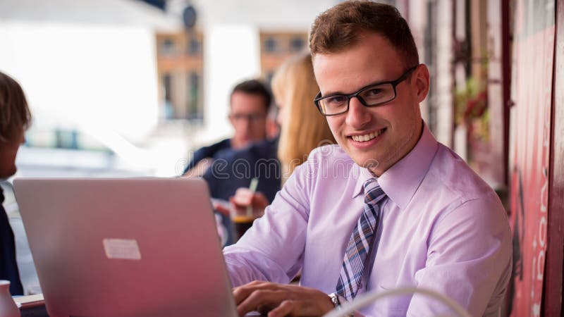 Jeune homme d'affaires à la mode dans une chemise et un portrait de lien. Il est travail image stock Jeune homme d'affaires à la mode dans une chemise et un portrait de lien. Il est travail image stock