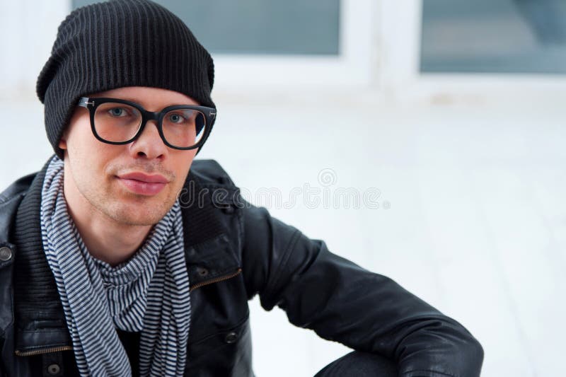 Jeune homme dans des vêtements sport se reposant sur le plancher photo libre de droits Jeune homme dans des vêtements sport se reposant sur le plancher photo libre de droits
