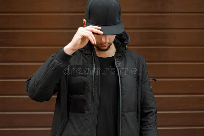 Jeune homme dans une casquette de baseball à la mode noire images libres de droits Jeune homme dans une casquette de baseball à la mode noire images libres de droits