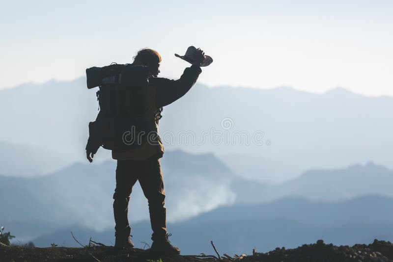 Jeune homme de hippie avec le sac ? dos appr?ciant le coucher du soleil sur la montagne maximale image stock Jeune homme de hippie avec le sac ? dos appr?ciant le coucher du soleil sur la montagne maximale image stock