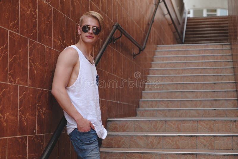 Jeune homme de hippie posant la position sur les escaliers photo stock Jeune homme de hippie posant la position sur les escaliers photo stock