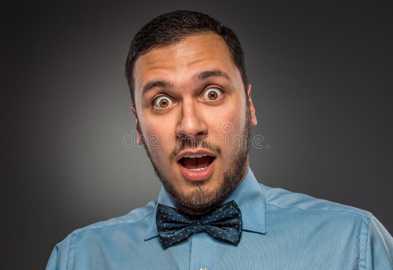 Jeune homme de portrait dans la chemise bleue, regardant avec la stupéfaction photographie stock Jeune homme de portrait dans la chemise bleue, regardant avec la stupéfaction photographie stock