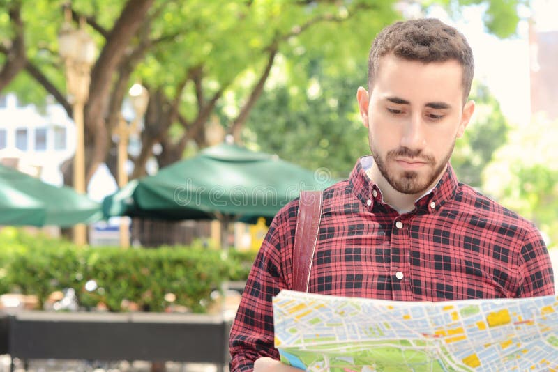 Jeune homme de touristes regardant une carte photo libre de droits Jeune homme de touristes regardant une carte photo libre de droits