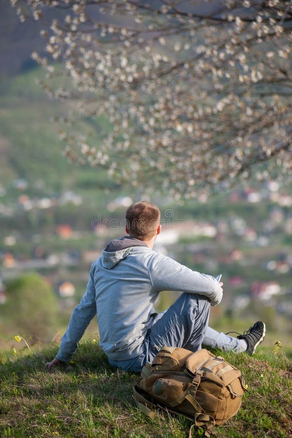 Jeune homme de voyageur avec le sac à dos sur la colline image libre de droits Jeune homme de voyageur avec le sac à dos sur la colline image libre de droits