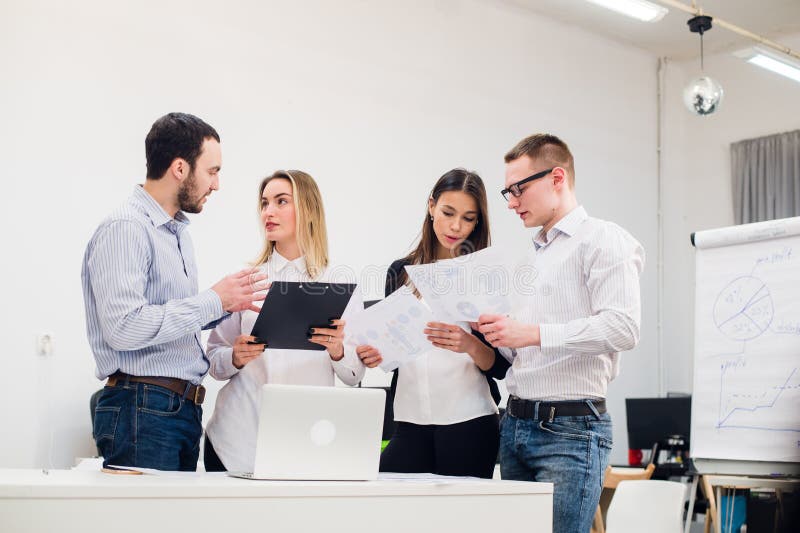 Jeune homme discutant la recherche de marché avec des collègues lors d'une réunion Équipe de professionnels ayant la conversation image stock Jeune homme discutant la recherche de marché avec des collègues lors d'une réunion Équipe de professionnels ayant la conversation image stock