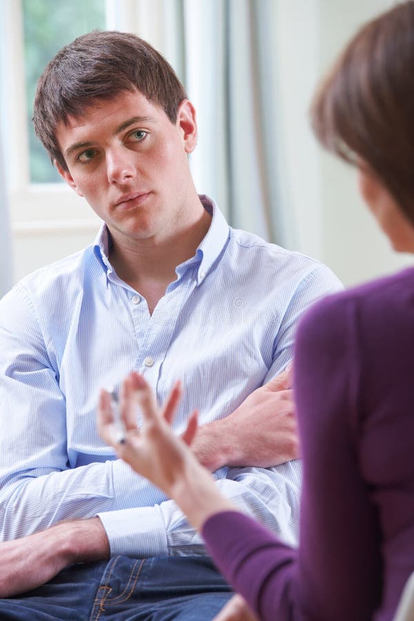 Jeune homme déprimé parlant au conseiller photos stock