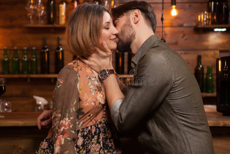Jeune homme embrassant son fiancé une nuit dans un bar de cru photos libres de droits Jeune homme embrassant son fiancé une nuit dans un bar de cru photos libres de droits