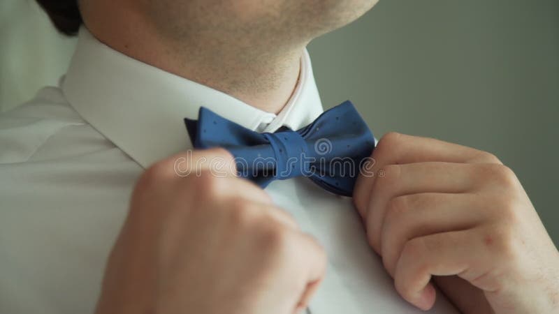 Jeune homme en chemise blanche ajustant la couture du cul