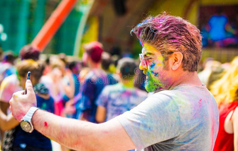 Jeune homme en verres avec la poudre de holi sur son visage photo libre de droits Jeune homme en verres avec la poudre de holi sur son visage photo libre de droits