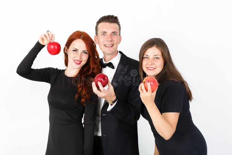 Jeune homme et deux femmes dans le noir sur un fond blanc photos stock Jeune homme et deux femmes dans le noir sur un fond blanc photos stock