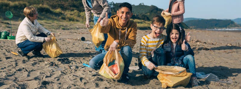 Jeune homme et enfants à nettoyer la plage image stock