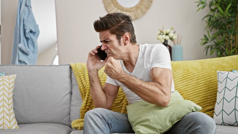Jeune homme hispanique parlant au téléphone en colère se disputant à la maison