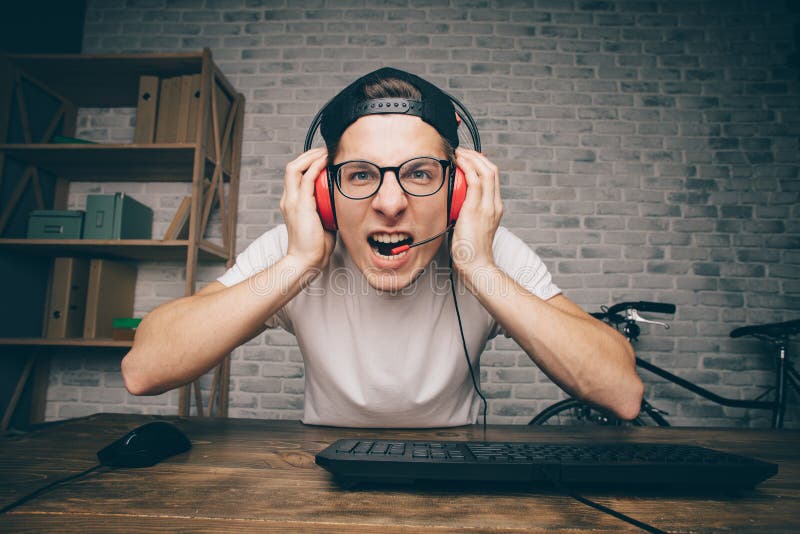 Jeune homme jouant le jeu à la maison et coulant la vidéo de playthrough ou de revue du projet photos stock Jeune homme jouant le jeu à la maison et coulant la vidéo de playthrough ou de revue du projet photos stock