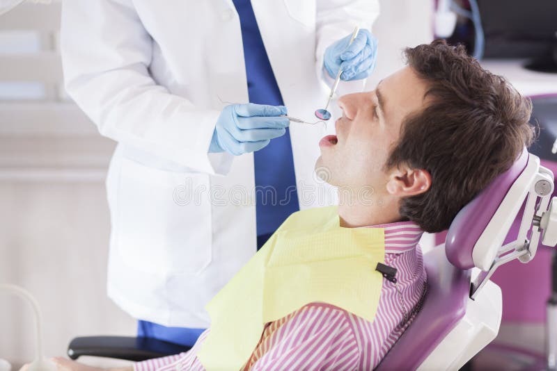 Jeune homme lors d'une visite au dentiste image stock Jeune homme lors d'une visite au dentiste image stock