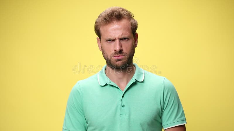 Jeune homme occasionnel dans le polo vert sur le fond jaune banque de vidéos
