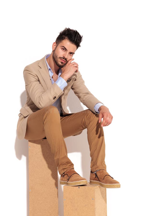 Jeune homme occasionnel futé jugeant principal dans sa paume image stock Jeune homme occasionnel futé jugeant principal dans sa paume image stock