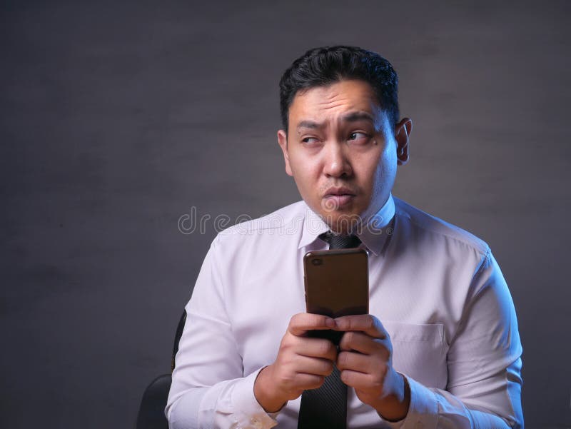 Jeune homme pensant tout en causant au t?l?phone intelligent photos libres de droits Jeune homme pensant tout en causant au t?l?phone intelligent photos libres de droits