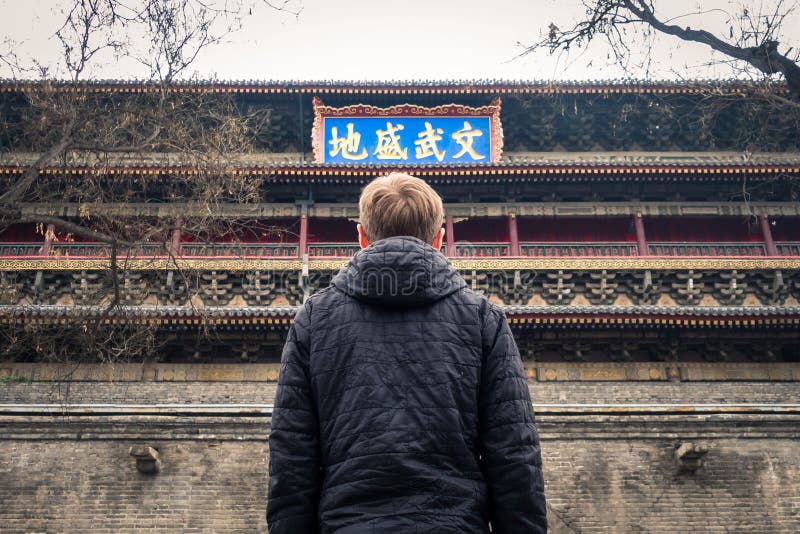 Jeune homme regardant se sentir chinois de symboles de Xi'an Belltower