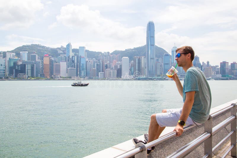 Jeune homme s'asseyant sur le littoral en Hong Kong images libres de droits Jeune homme s'asseyant sur le littoral en Hong Kong images libres de droits