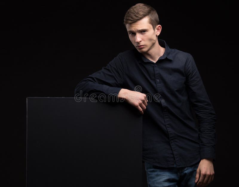 Jeune homme sexy montrant la présentation, se dirigeant sur la plaquette images stock Jeune homme sexy montrant la présentation, se dirigeant sur la plaquette images stock