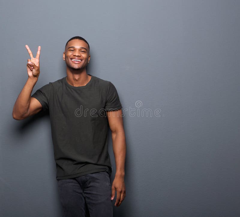 Jeune homme souriant montrant le signe de paix de main photos libres de droits Jeune homme souriant montrant le signe de paix de main photos libres de droits