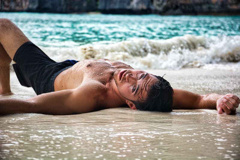 Jeune Homme Torse Nu Sur La Plage Allongé Sur Le Sable Photo stock - Image du pecs, plage: 235099644