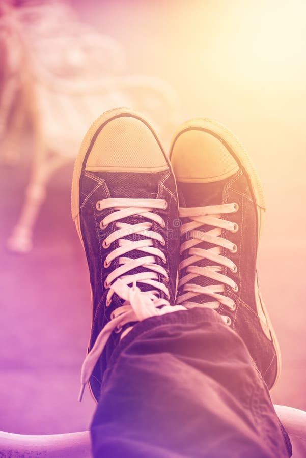 Jeune homme urbain détendant avec des jambes croisées photos stock Jeune homme urbain détendant avec des jambes croisées photos stock