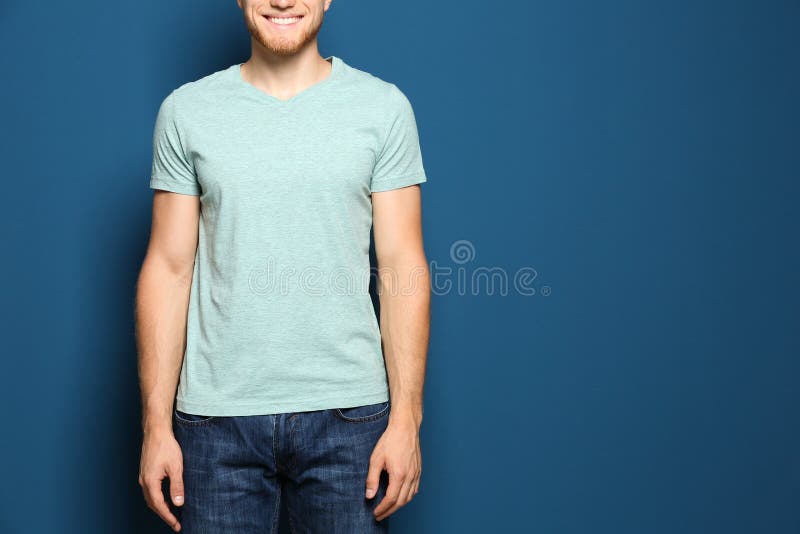 Jeune homme utilisant le T-shirt vide sur le bleu, plan rapproché Maquette pour la conception photographie stock Jeune homme utilisant le T-shirt vide sur le bleu, plan rapproché Maquette pour la conception photographie stock