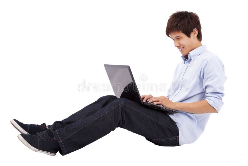 Jeune homme à l'aide de l'ordinateur portatif sur l'étage image stock Jeune homme à l'aide de l'ordinateur portatif sur l'étage image stock