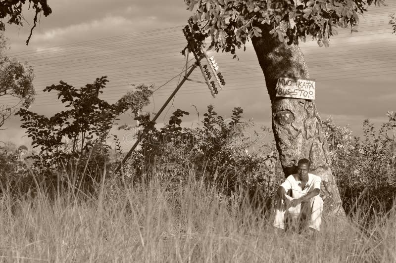 Jeune homme à un arrêt d'autobus au Zimbabwe rural, Afrique image stock Jeune homme à un arrêt d'autobus au Zimbabwe rural, Afrique image stock