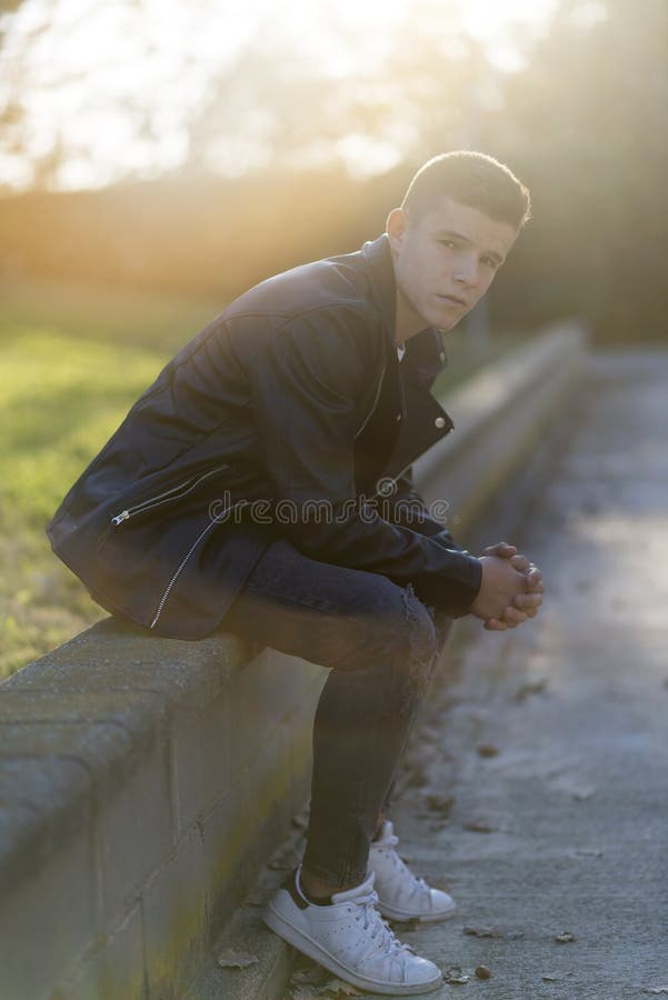 Jeune homme élégant dans la veste en cuir regardant l'appareil-photo, I se reposant photographie stock libre de droits