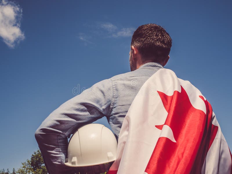 Jeune ingénieur, masque blanc et drapeau canadien images stock Jeune ingénieur, masque blanc et drapeau canadien images stock